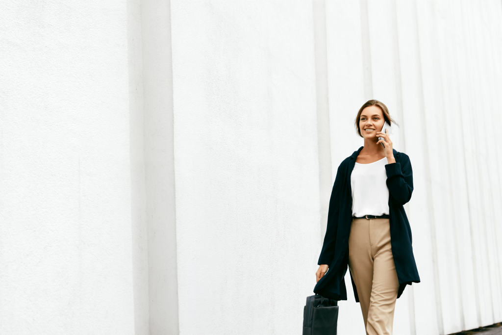 frau mit handy unterwegs am telefonieren über die moderne telefonanlage